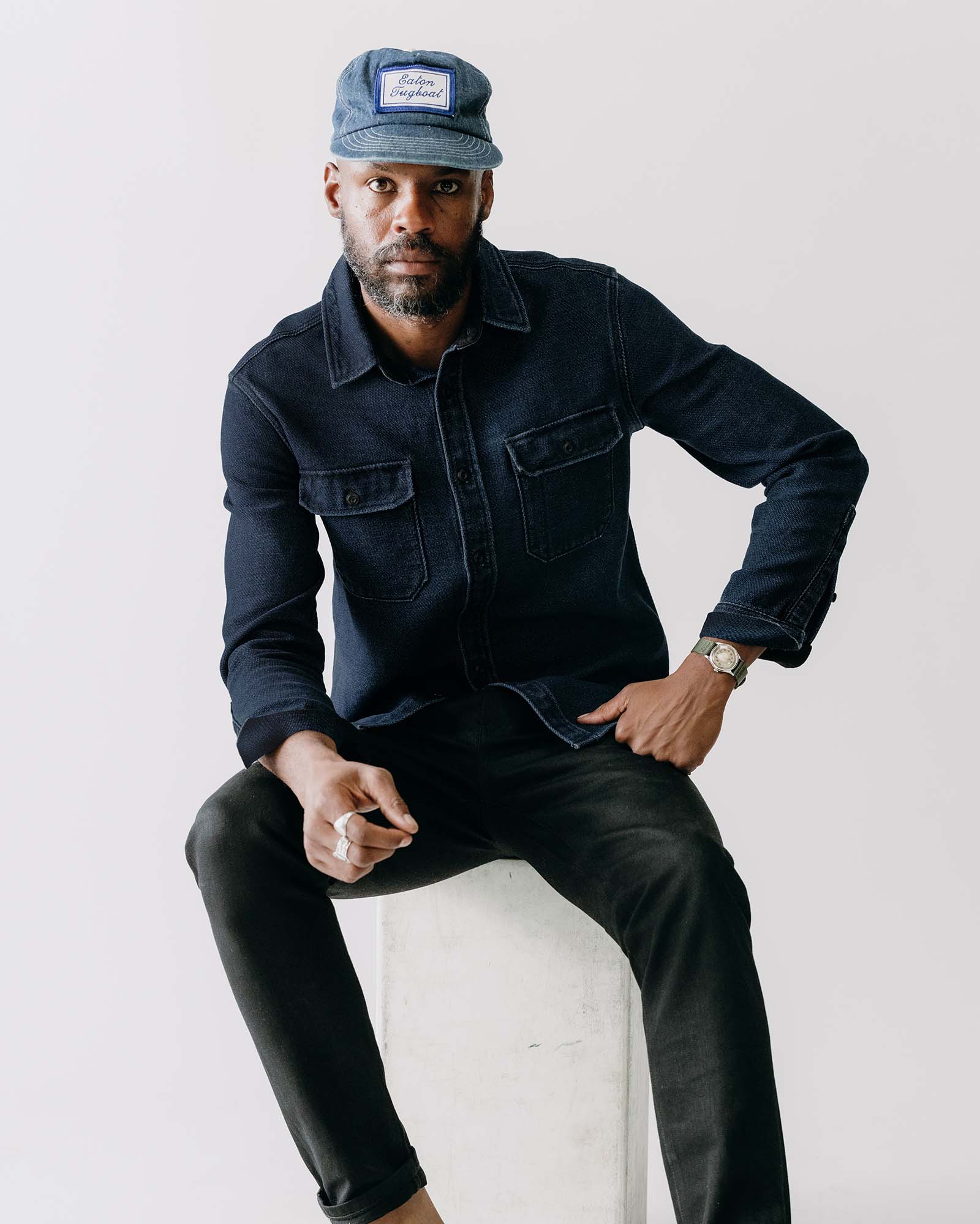 fit model sitting wearing The Division Shirt in Rinsed Indigo, Wovens by Taylor Stitch