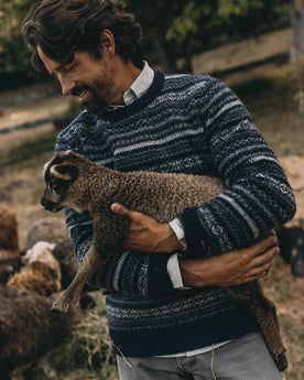 fit model holding a sheep wearing The Eastmoor Sweater in Navy Fair Isle Wool, Knits by Taylor Stitch
