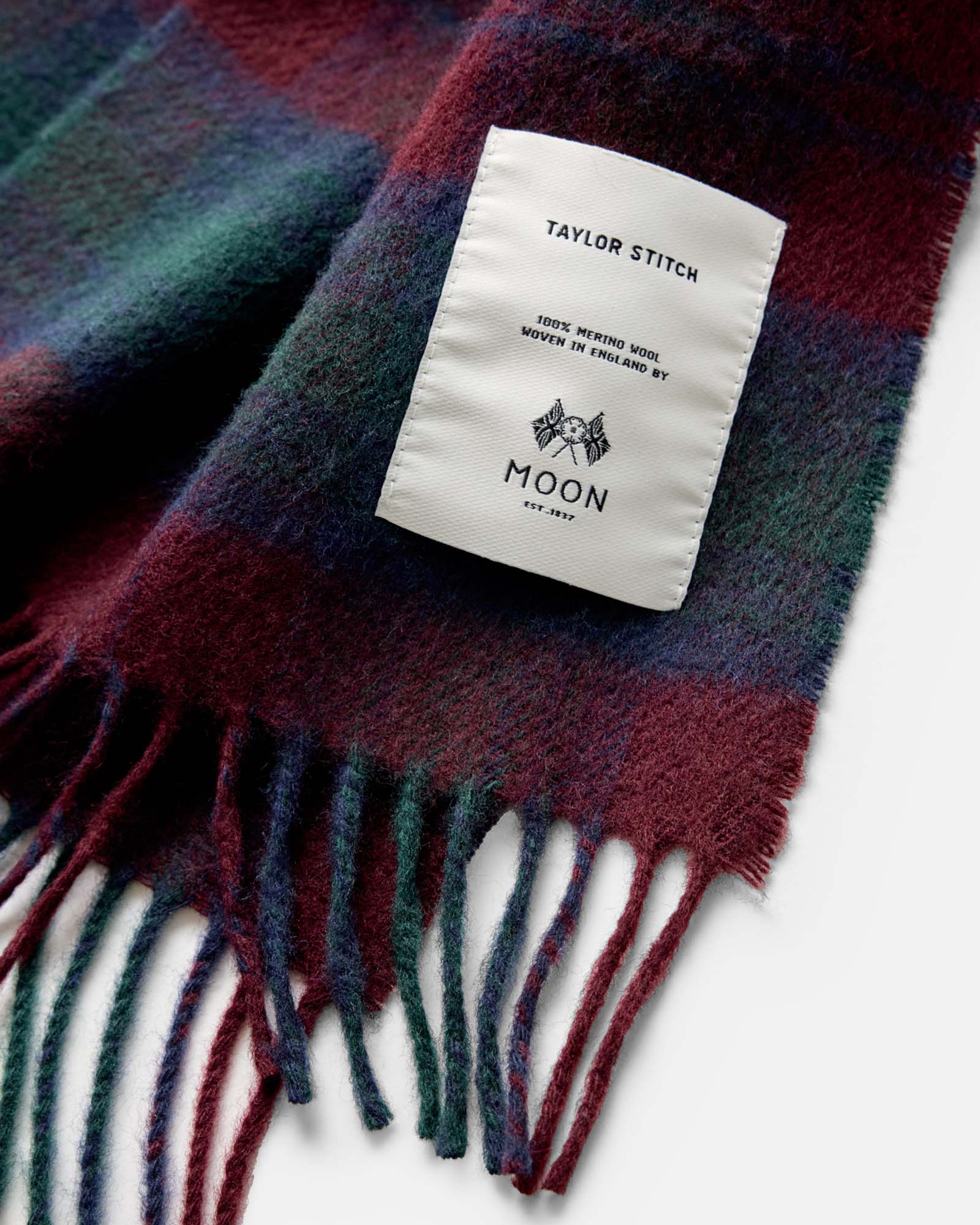 material shot of the label on The Fireside Scarf in Currant Plaid, Accessories by Taylor Stitch