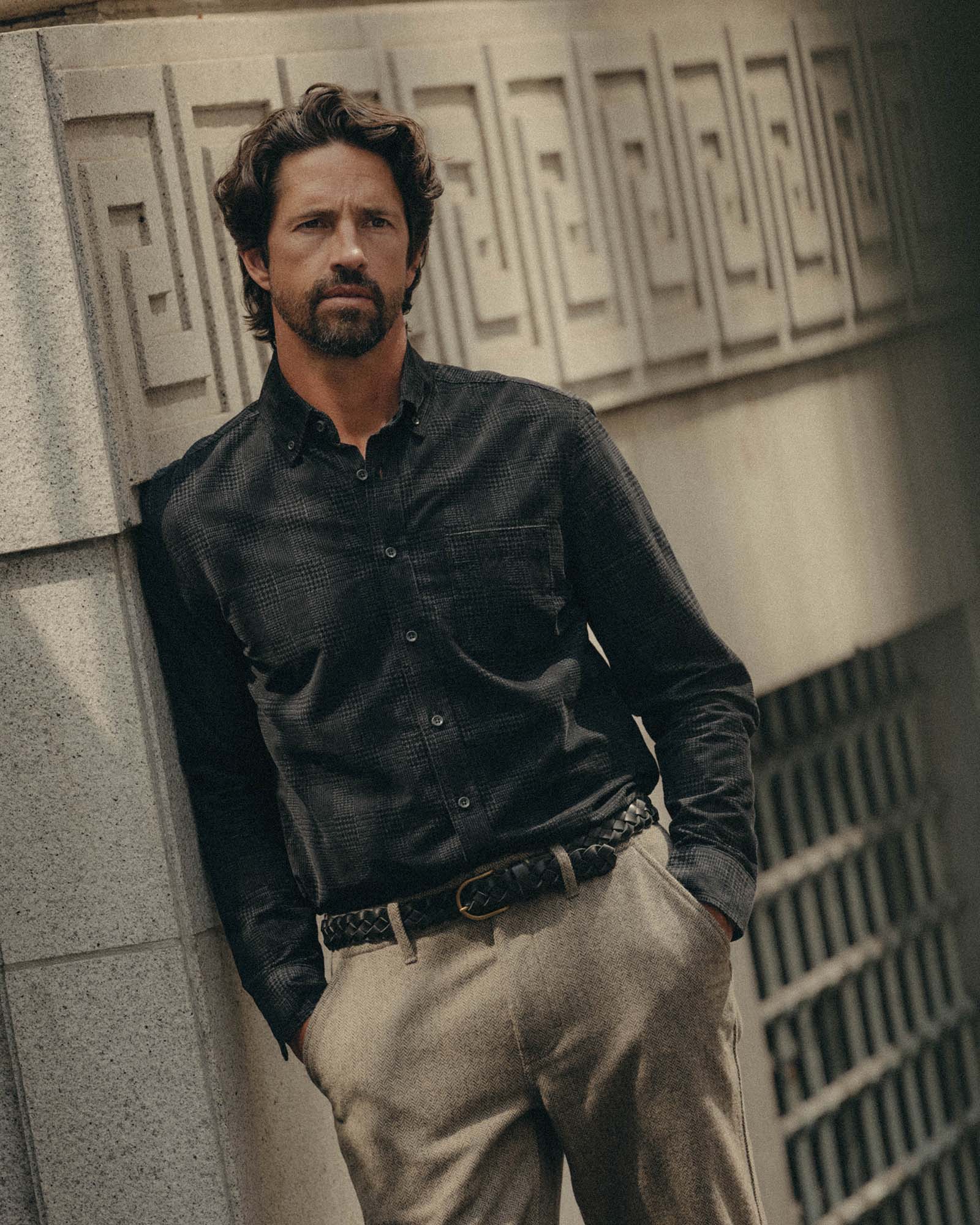 fit model leaning against the wall wearing The Jack in Heather Coal Check Pincord, Wovens by Taylor Stitch