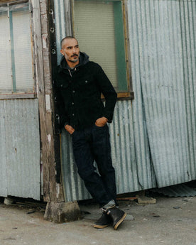 fit model leaning against the wall wearing The Long Haul Jacket in Black Indigo Waffle, Outerwear by Taylor Stitch