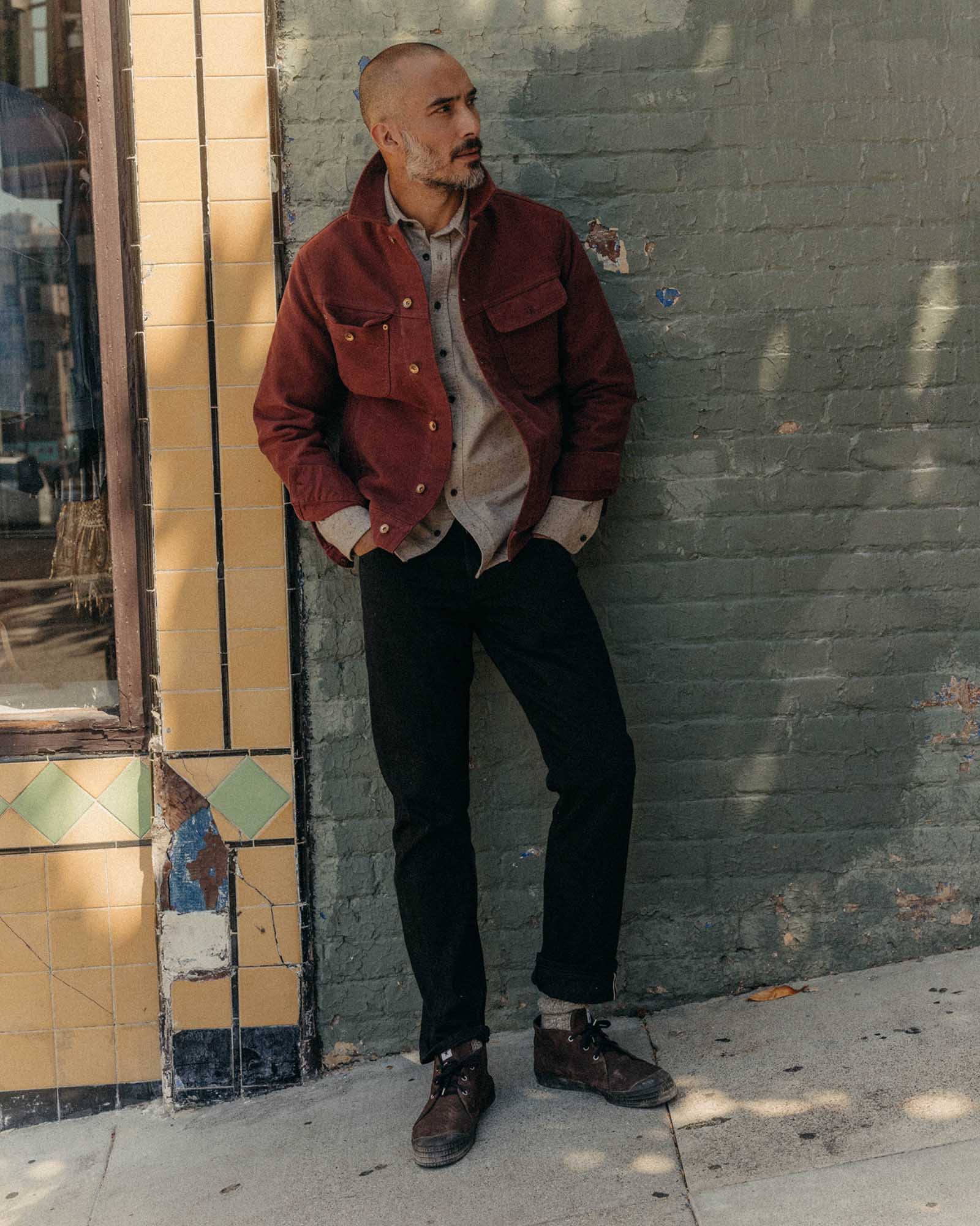 fit model leaning against the wall wearing The Long Haul Jacket in Dried Cherry Moleskin, Outerwear by Taylor Stitch