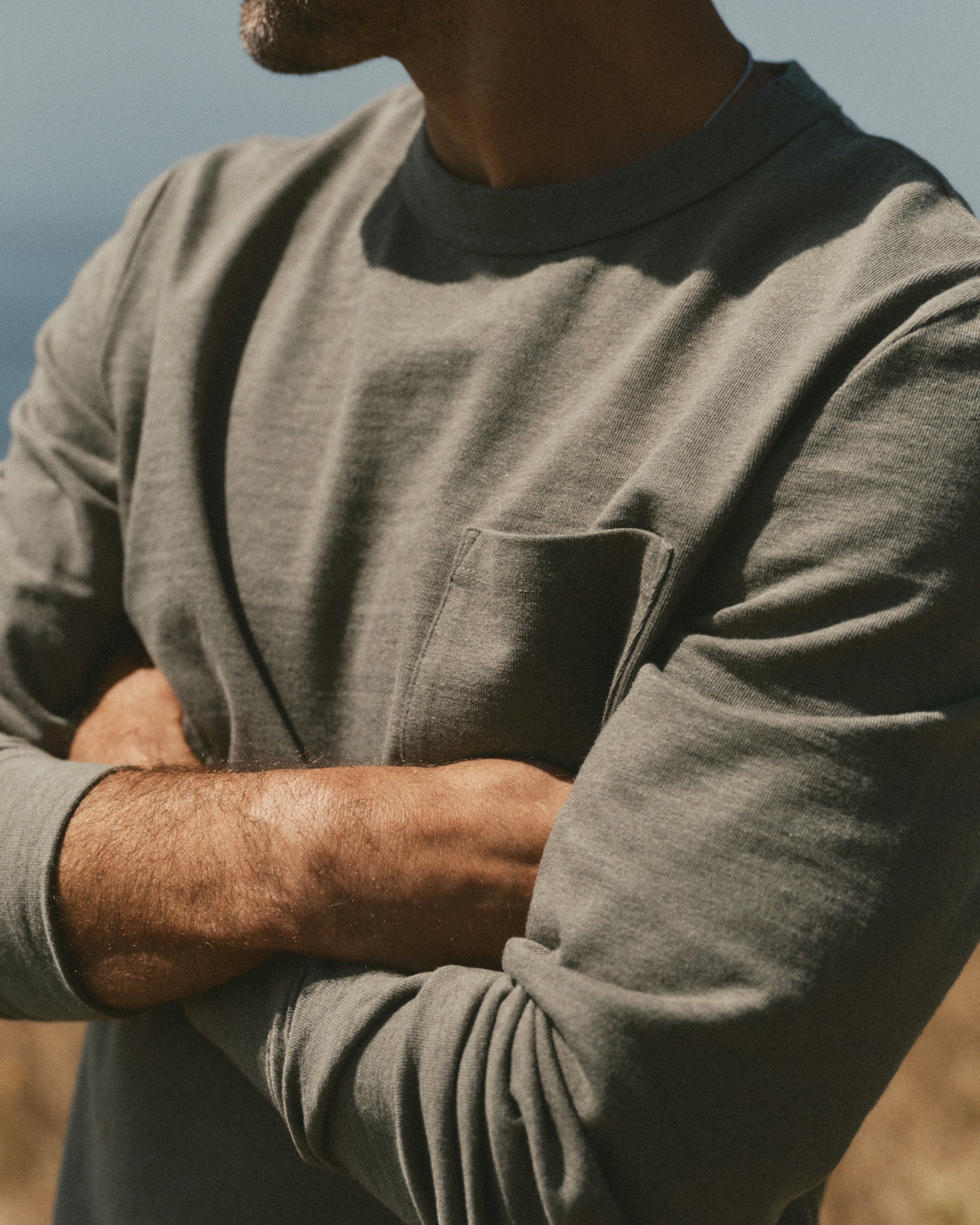 fit model leaning against the wall wearing The Long Sleeve Shop Tee in Army Twist, Knits by Taylor Stitch