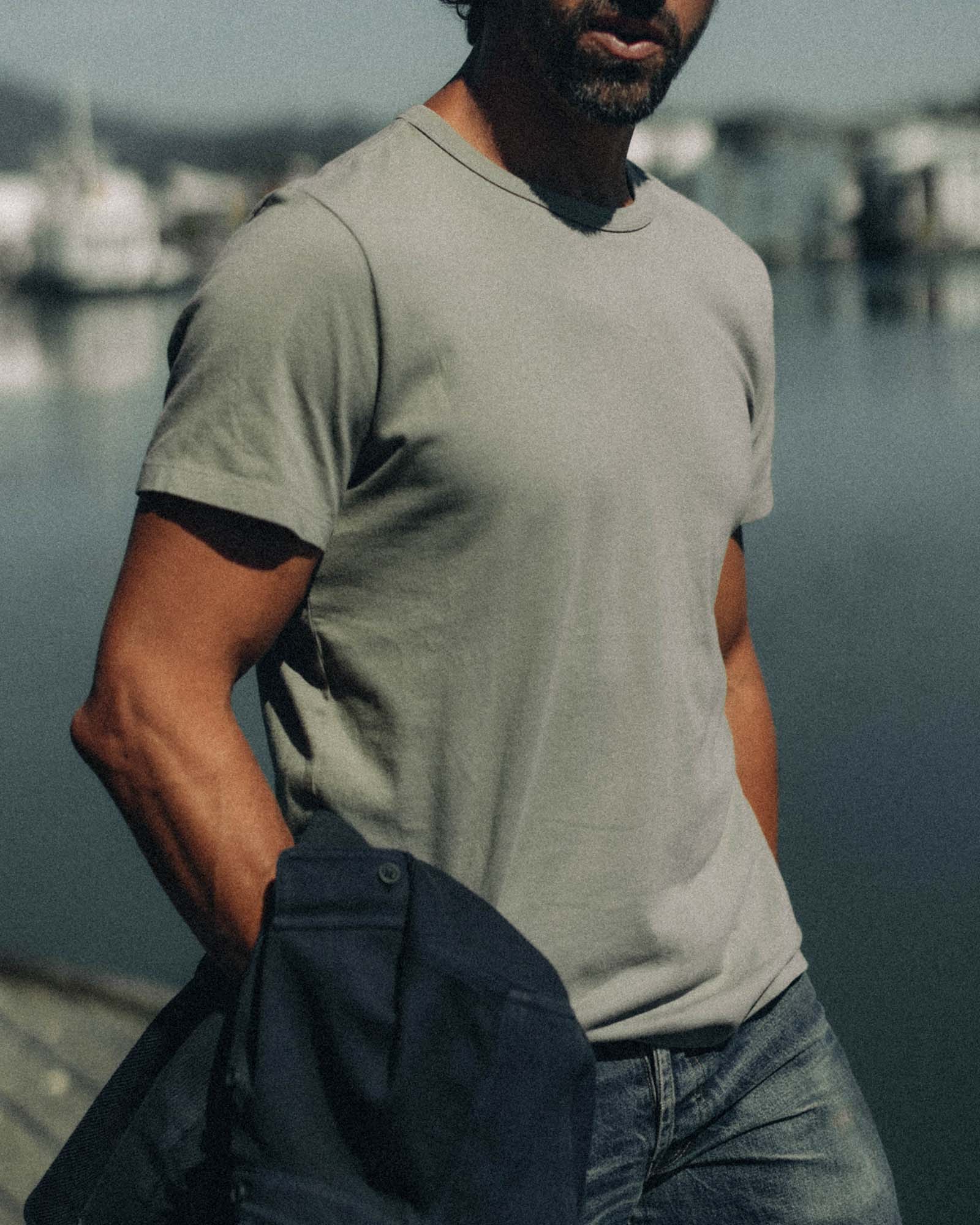 fit model sitting leaning against the wall in The Organic Cotton Tee in Sage, Knits by Taylor Stitch