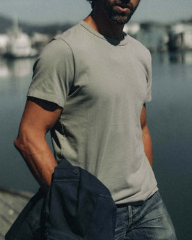 fit model sitting leaning against the wall in The Organic Cotton Tee in Sage, Knits by Taylor Stitch