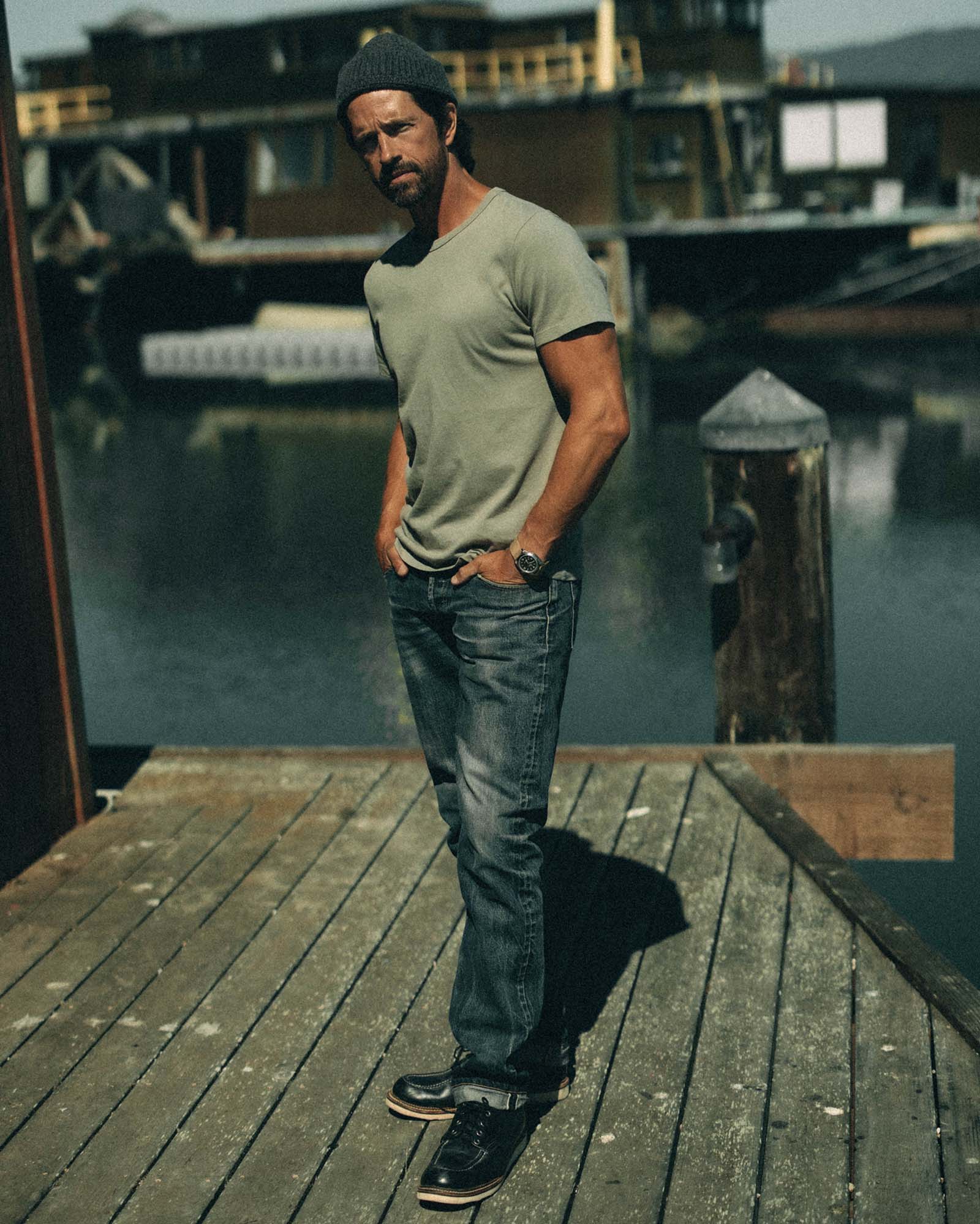 fit model with a jacket over his shoulder wearing The Organic Cotton Tee in Sage, Knits by Taylor Stitch