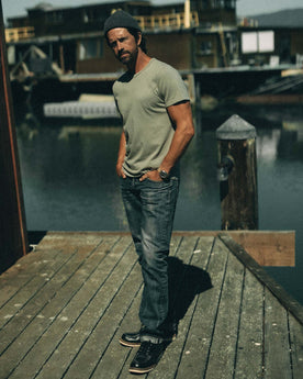 fit model with a jacket over his shoulder wearing The Organic Cotton Tee in Sage, Knits by Taylor Stitch