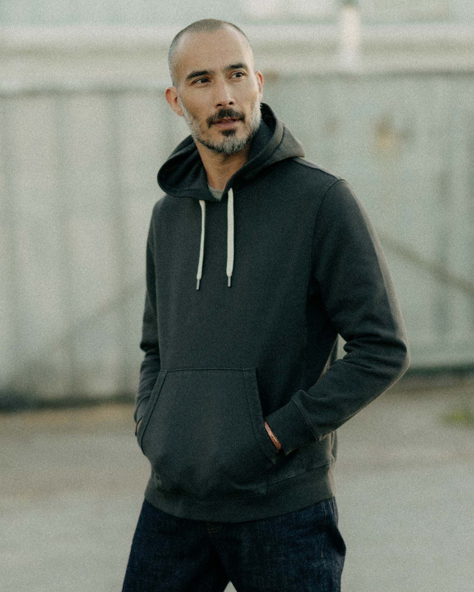fit model posing in The Shop Hoodie in Faded Black, Knits by Taylor Stitch