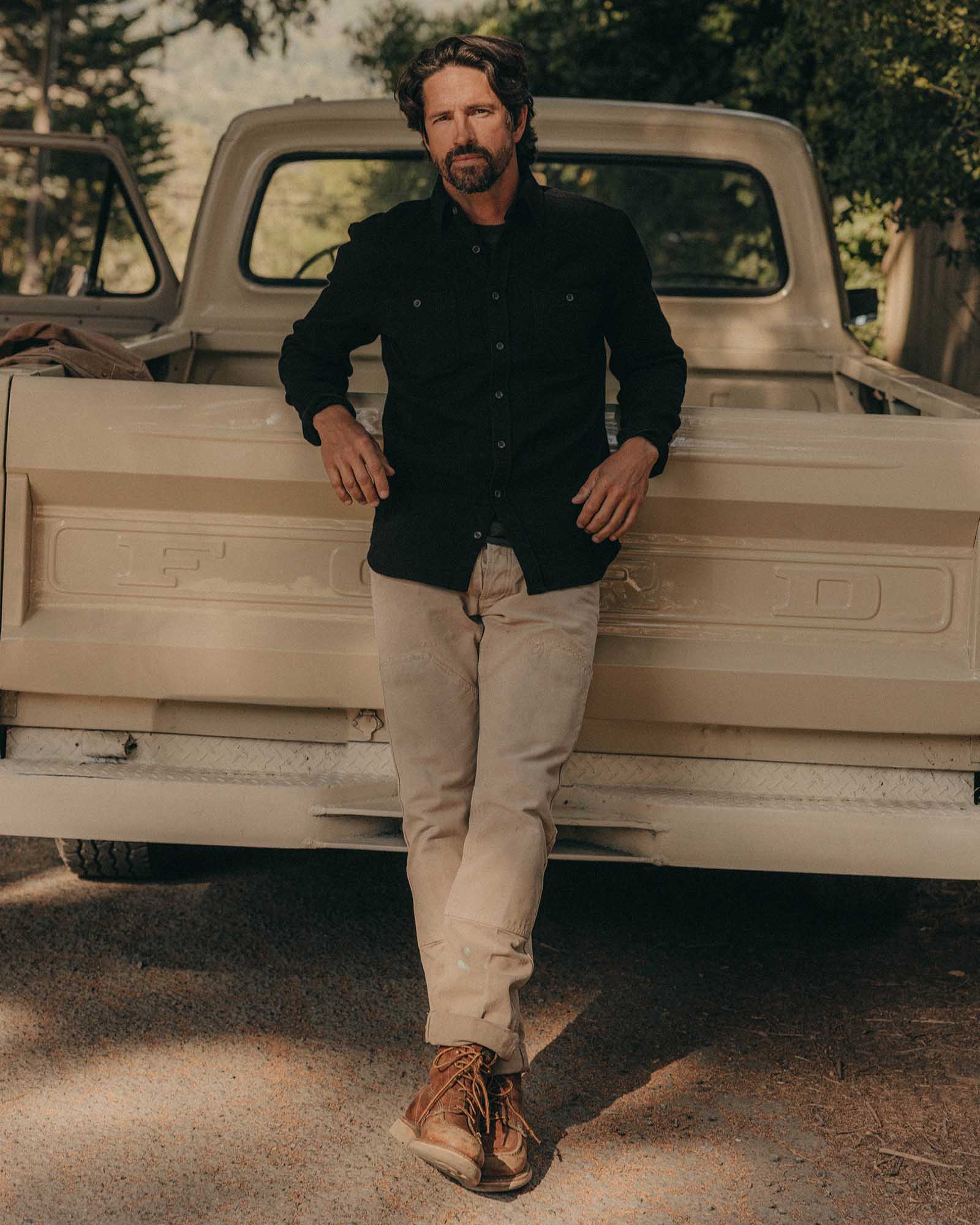 fit model leaning against a car wearing The Utility Shirt in Black Indigo Sashiko, Wovens by Taylor Stitch