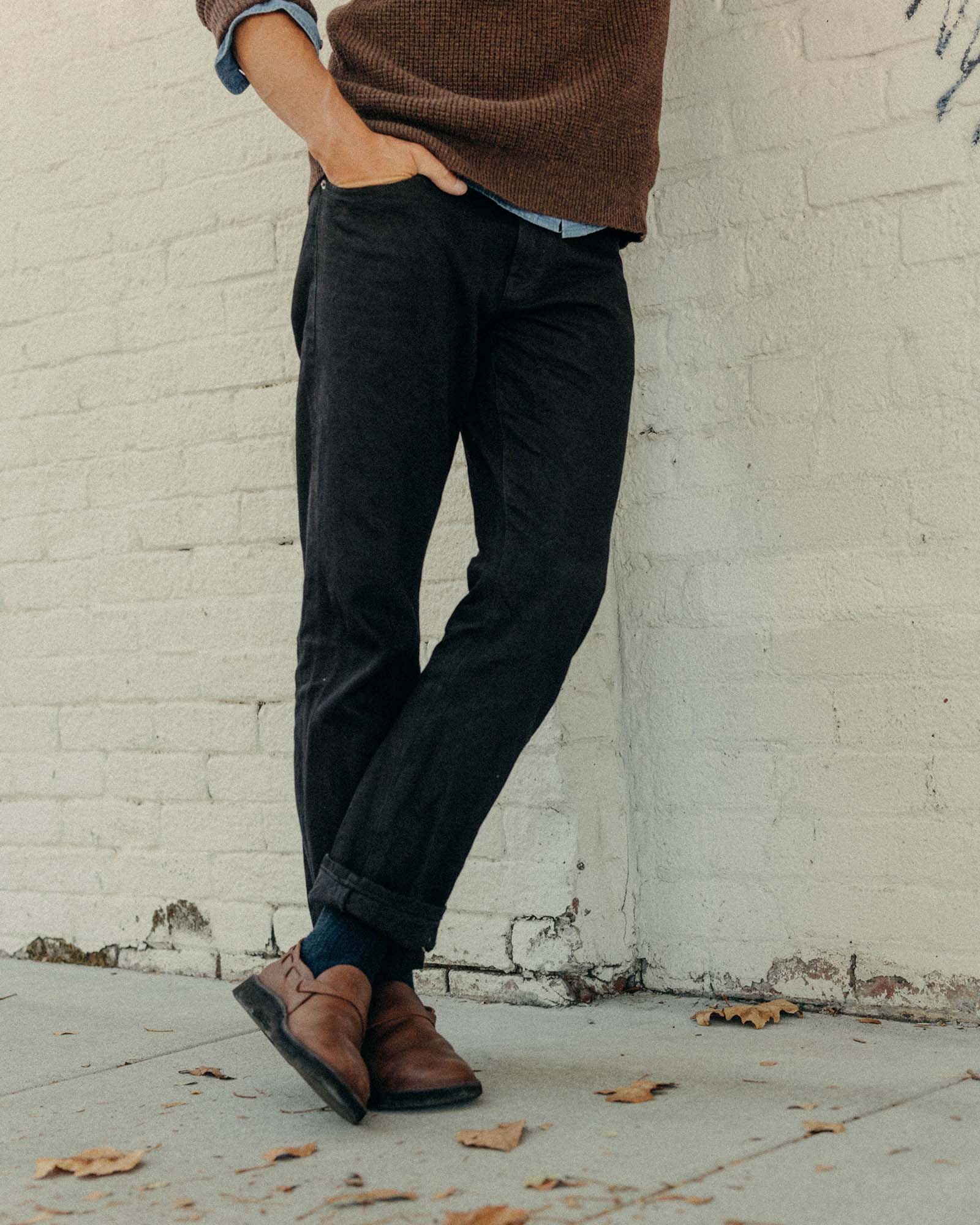 fit model walking wearing The Democratic Jean in Rigid Black Organic Selvedge, Bottoms by Taylor Stitch