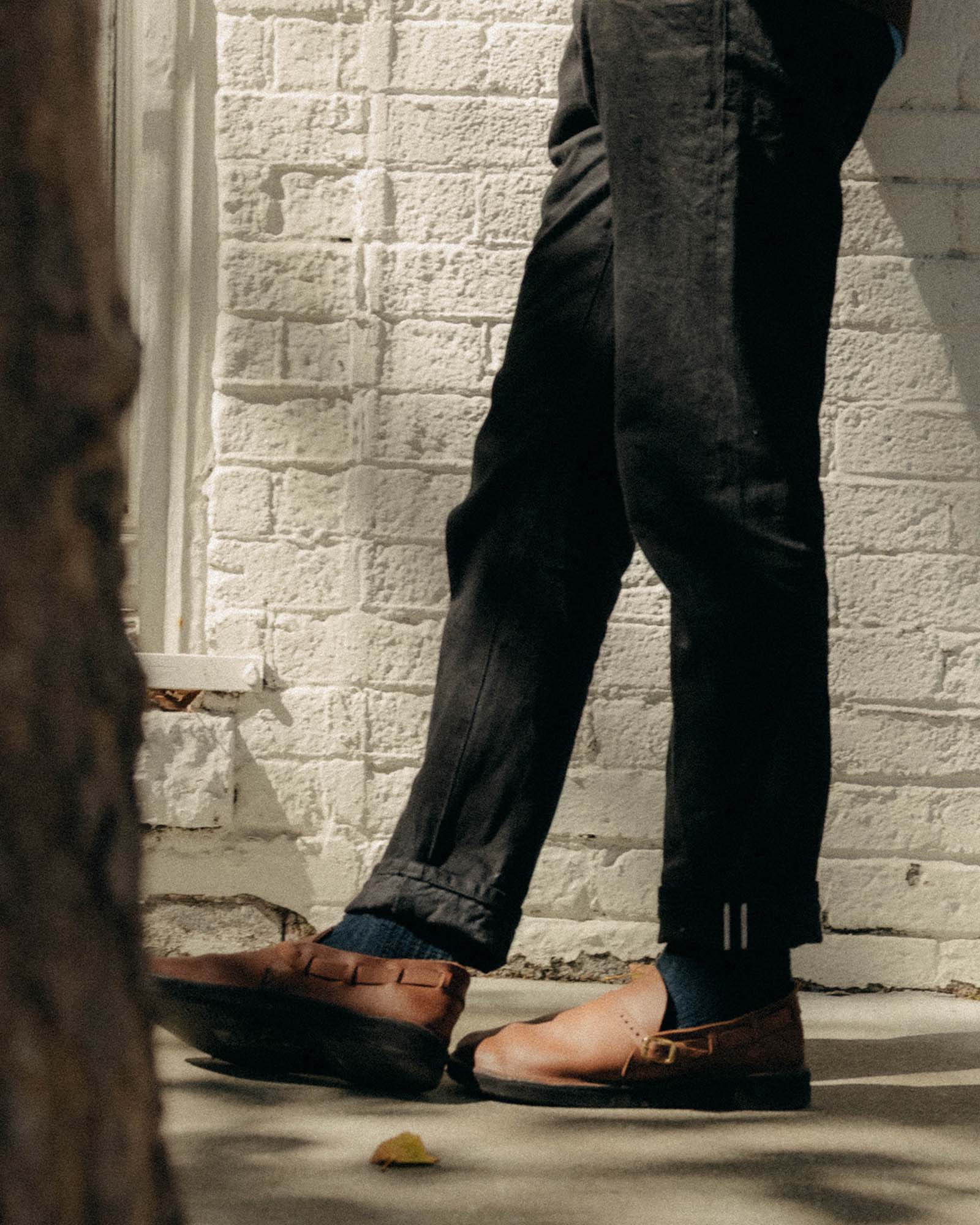 fit model standing wearing The Democratic Jean in Rigid Black Organic Selvedge, Bottoms by Taylor Stitch