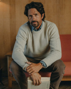 fit model sitting wearing The Eastmoor Sweater in Heather Ivory Wool, Knits by Taylor Stitch