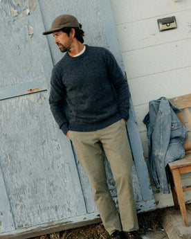 fit model leaning against the wall wearing The Eastmoor Sweater in Heather Night Wool, Knits by Taylor Stitch