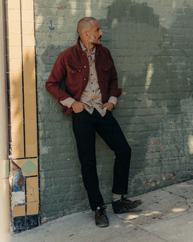 fit model standing wearing The Slim Jean in Rigid Black Organic Selvedge, Bottoms by Taylor Stitch