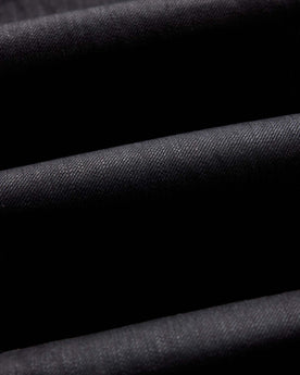 folded flatlay of the back of The Slim Jean in Rigid Black Organic Selvedge, Bottoms by Taylor Stitch