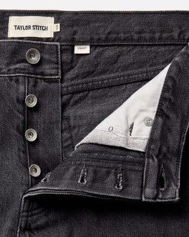 material shot of the button fly on The Straight Jean in Washed Black Organic Slub Selvedge, Bottoms by Taylor Stitch