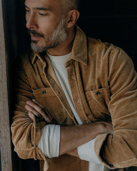 fit model leaning against the wall wearing The Utility Shirt in Bourbon Corduroy, Wovens by Taylor Stitch