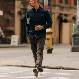 fit model sitting in The Carnegie Pant in Peat Herringbone