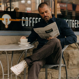 fit model sitting on the porch in The Carnegie Pant in Peat Herringbone
