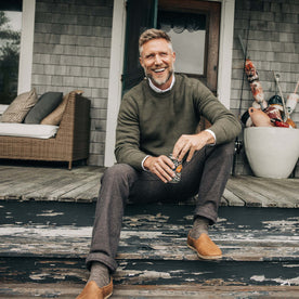 fit model sitting on the porch in The Carnegie Pant in Peat Herringbone
