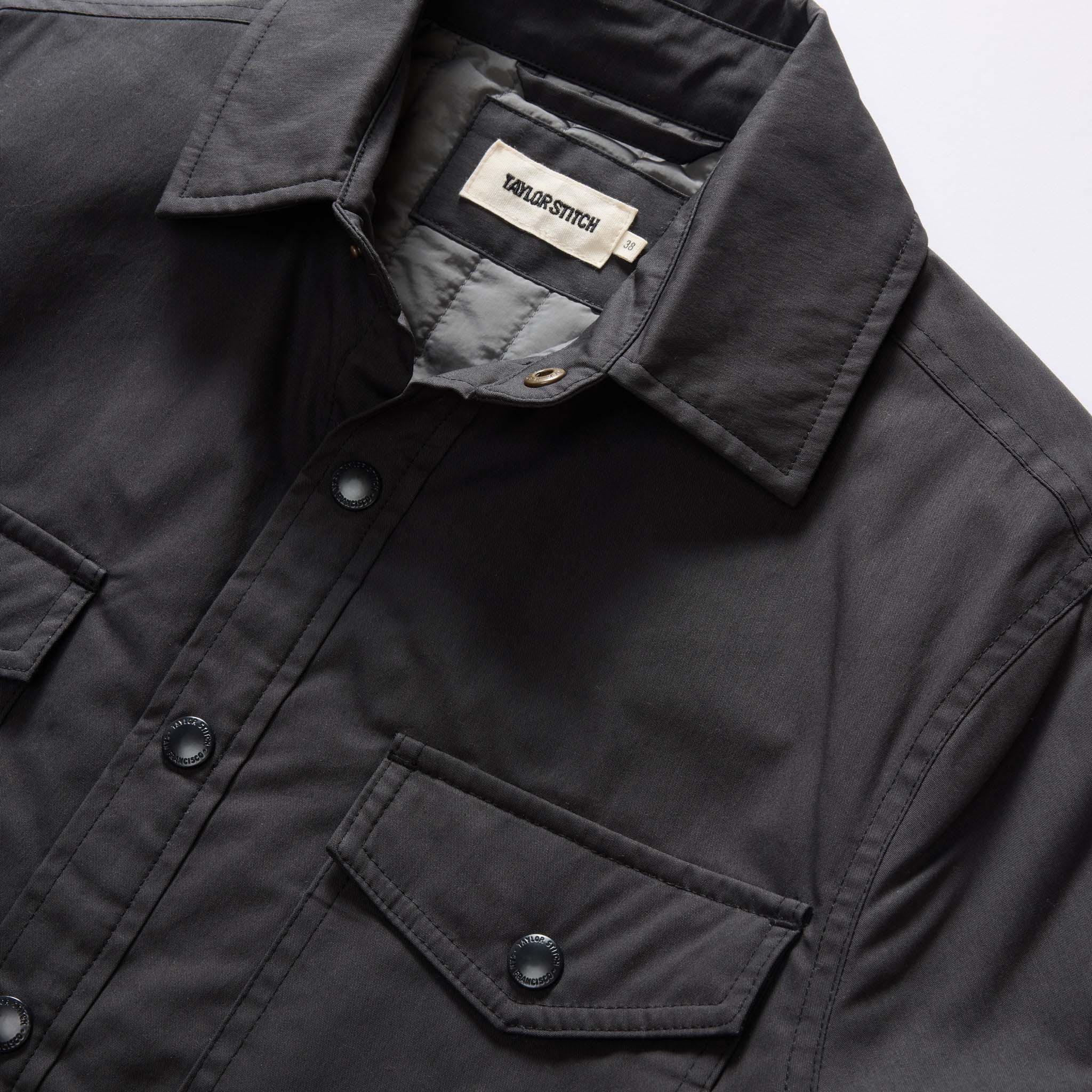 material shot of the collar and front snap pockets on The Lined Maritime Shirt Jacket in Coal, Wovens by Taylor Stitch