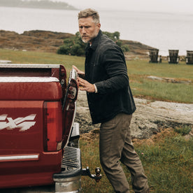 fit model closing the back of a truck in The Lined Utility Shirt in Washed Black Denim