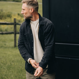 fit model adjusting the sleeves on The Lined Utility Shirt in Washed Black Denim