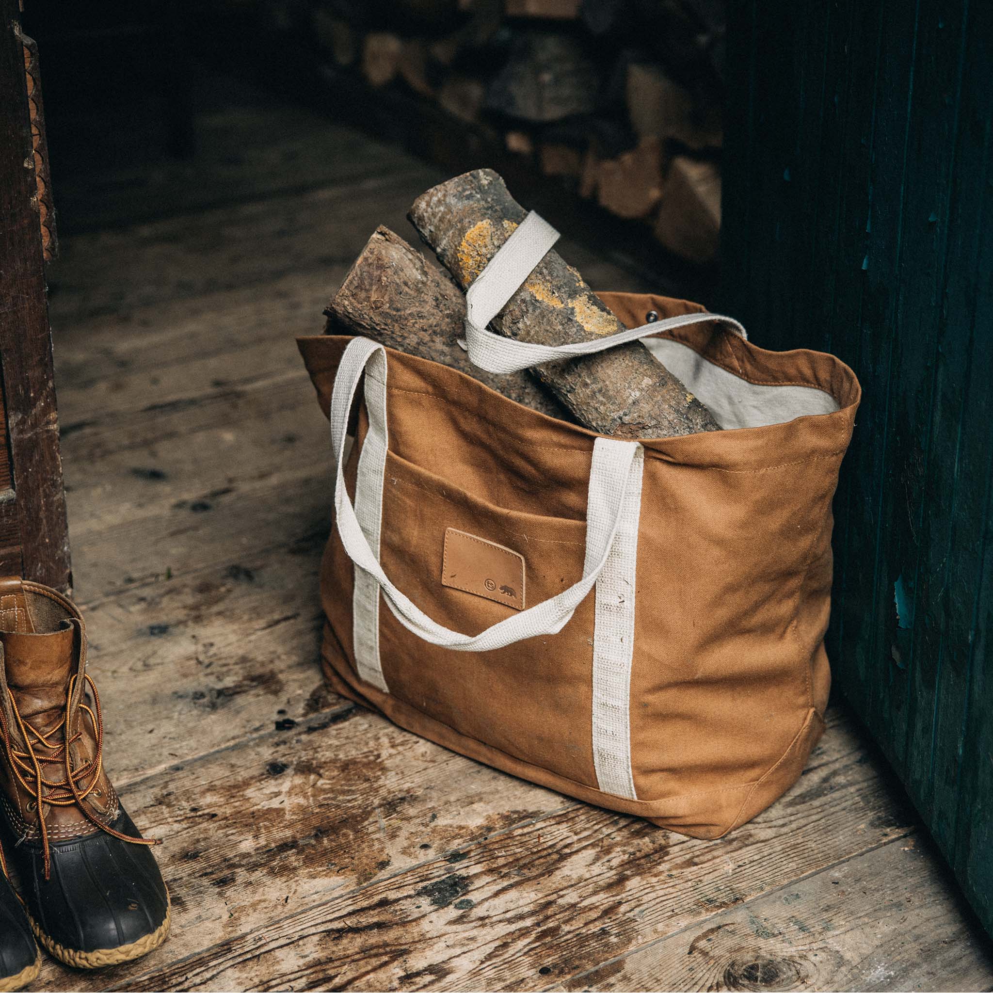 The Market Tote in Cedar Boss Duck with some logs inside, Accessories by Taylor Stitch