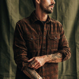 fit model adjusting the sleeves on The Saddler Shirt in Dark Roast Plaid Cord