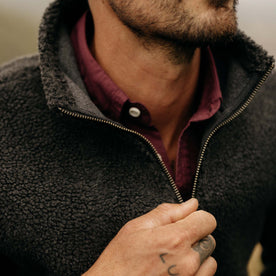 fit model zipping up The Nomad Pullover in Charcoal Heather Sherpa