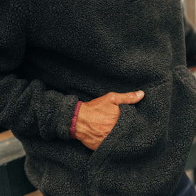 fit model with his hands in the pocket of The Nomad Pullover in Charcoal Heather Sherpa