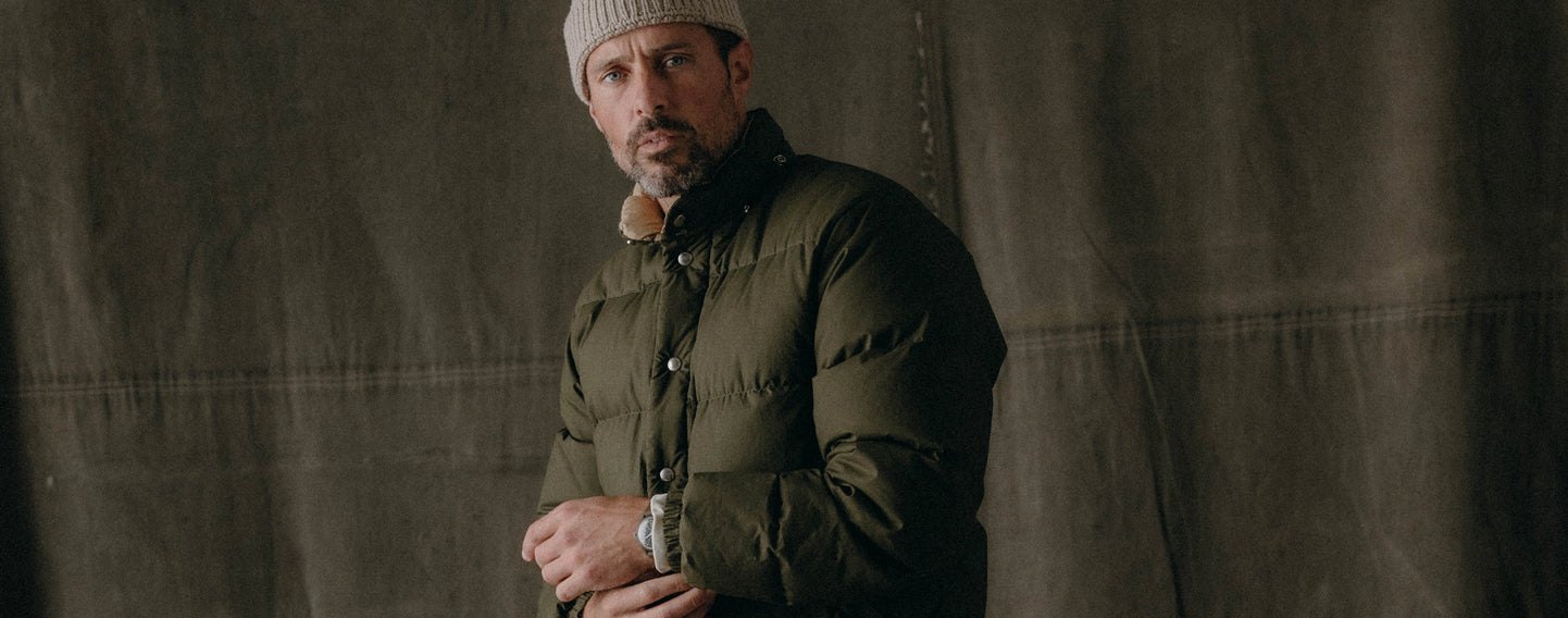 fit model posing in The Down Sweater in Olive Waxed Ripstop,  by Taylor Stitch