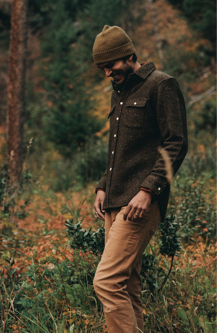 our guy wearing The Leeward Shirt in Olive Donegal from the front in a field of wildflowers