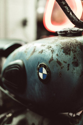 Close up on a rusty blue BMW motorbike fuel tank.