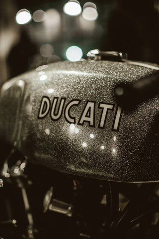 Close up of painted lettering on the side of a Ducatti fuel tank.