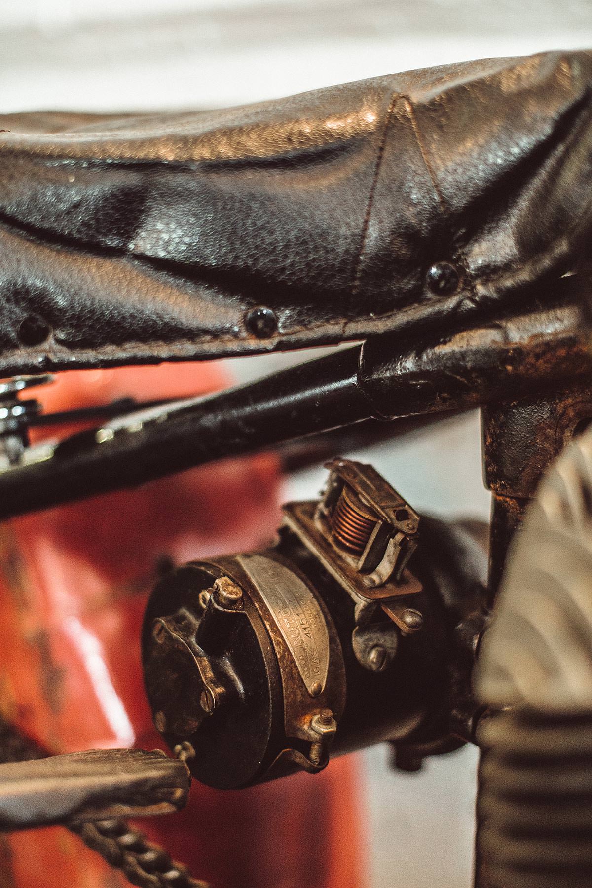 Close up shot of seat and motorcycle electrical component.