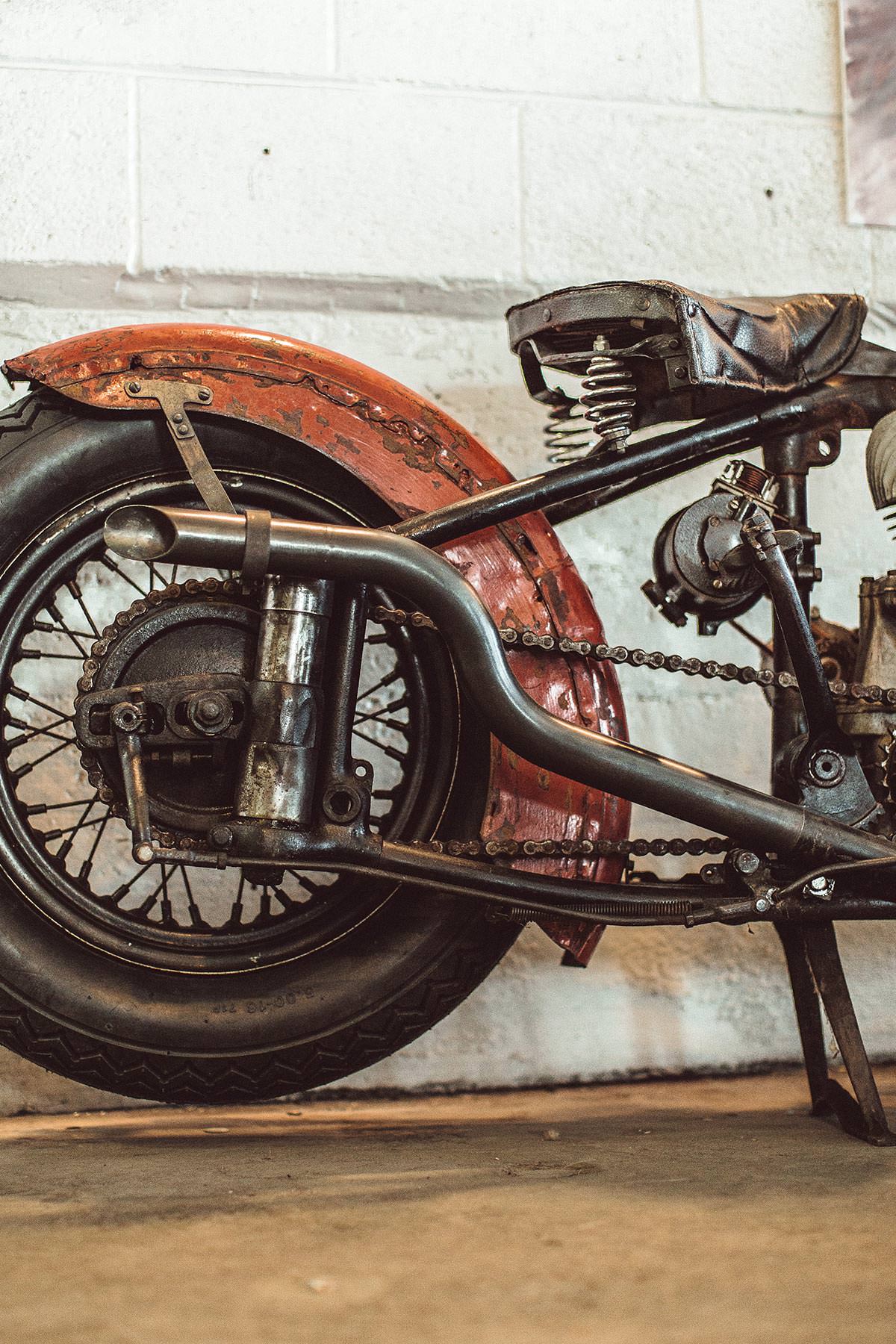 Side view of a beat-up red rear fender and wheel.