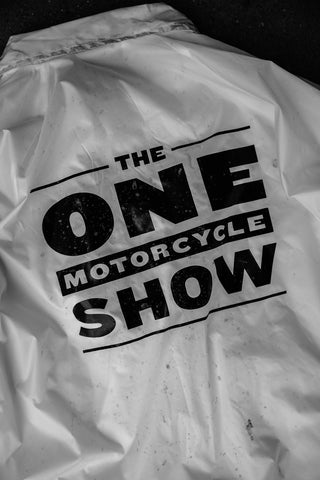 A screen-printed graphic on the back of a white jacket, reads 'The One Motorcycle Show.'