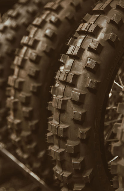 Close up on the tread in a row of three motorocycle tires.