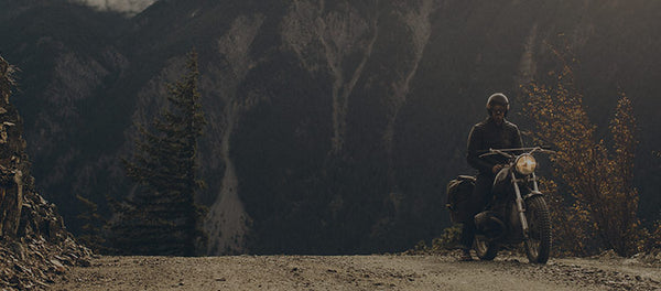 The Moto Jacket in Black Steerhide next to a motorcycle