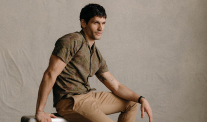 fit model sitting in The Hawthorne Shirt in Fatigue Olive Desert Palm