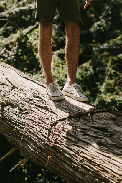 Our guy wearing the natural Vista sneakers, standing on log.