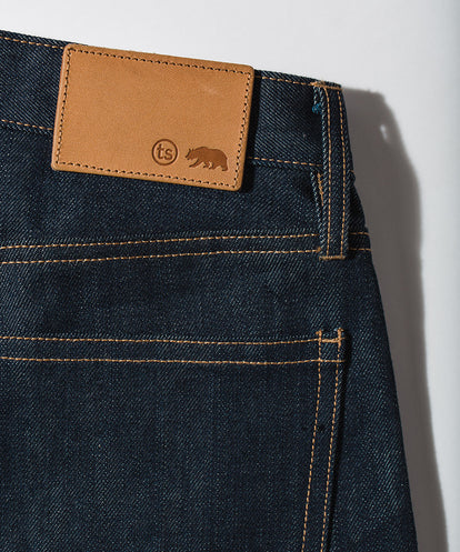 Detail shot of leather patch on rear wasitband of a pair of denim jeans.