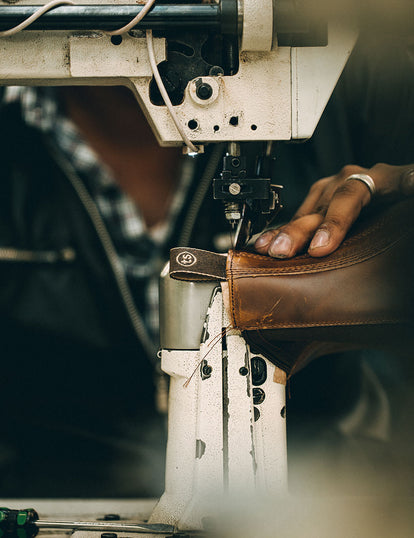 Close up of a boot being stitched on a machine.