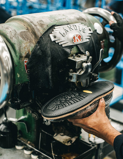 A Vibram sole being machine stitched onto an upper.