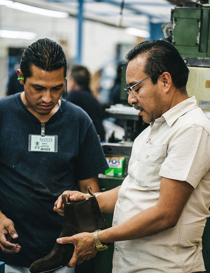 Two employees inspecting an in-process boot.