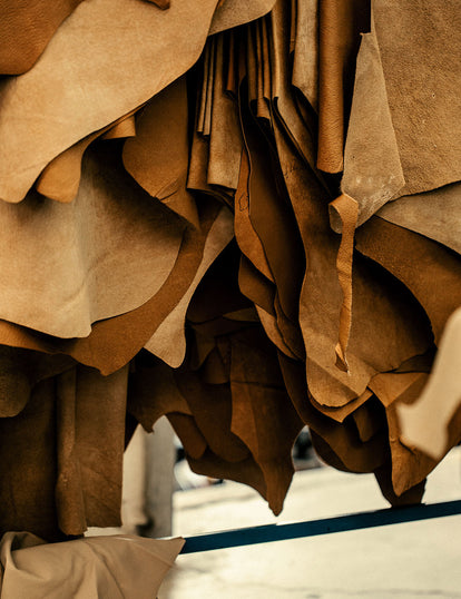 Assorted leather panels and offcuts, hanging.