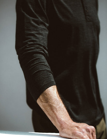 Close-up shot of a model wearing our black merino henley.