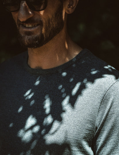 Our guy wearing a blue merino tee, dappled in shadow.