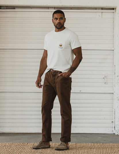 Our guy in tee and workwear pants in front of a white-painted garage door.
